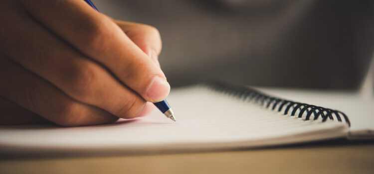 Man hand with pen writing on notebook.